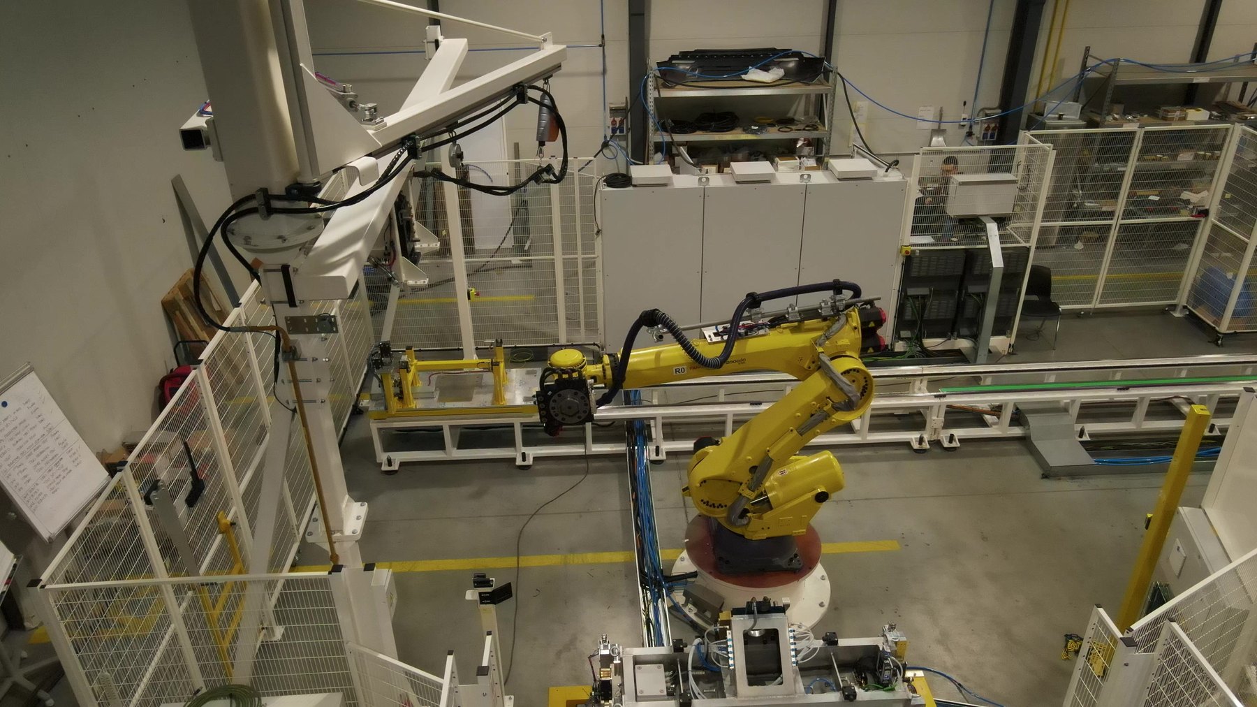 Tailgate bonding cell — FANUC robot at the adhesive station.