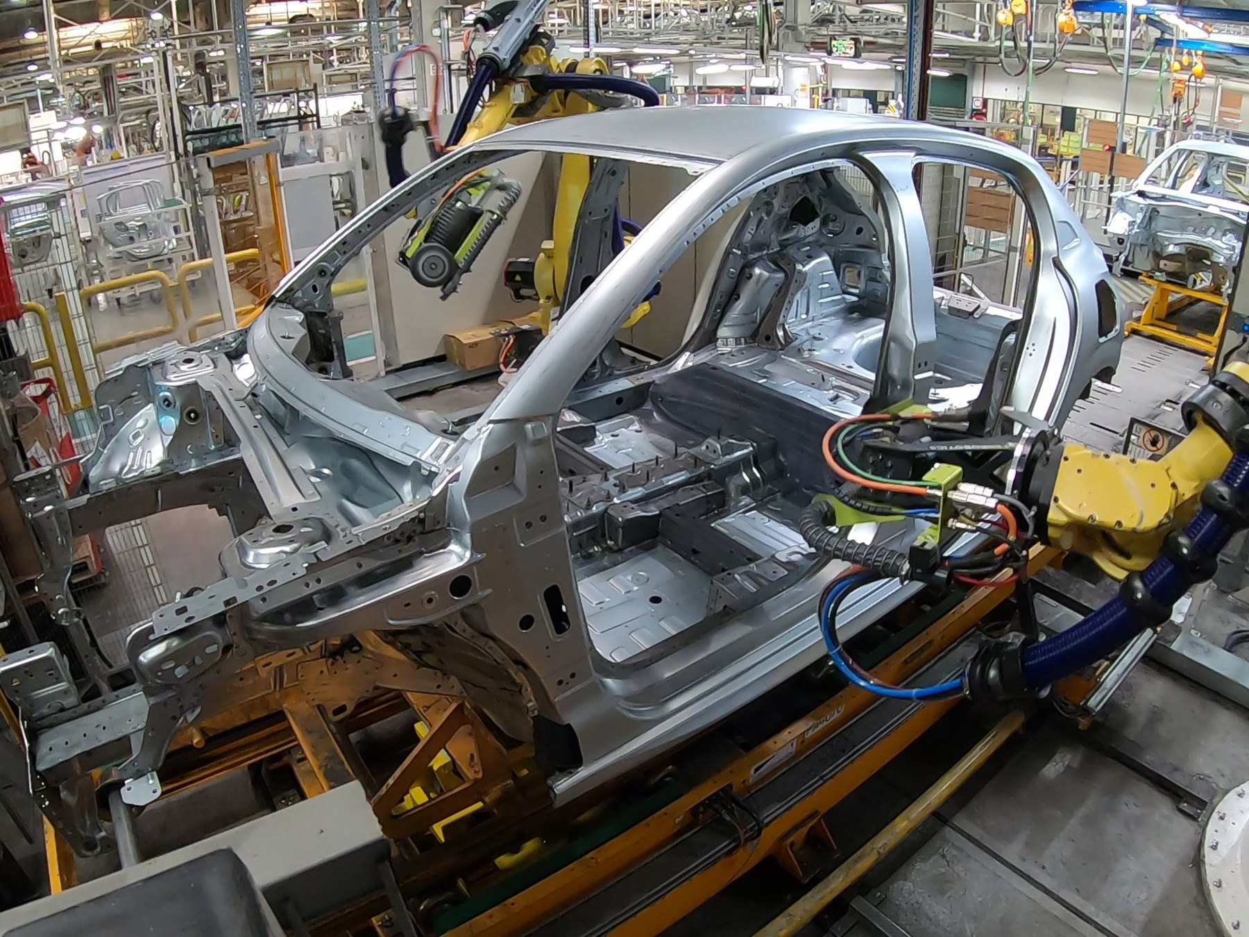 Force-controlled tooling working on a body in white, on the line.