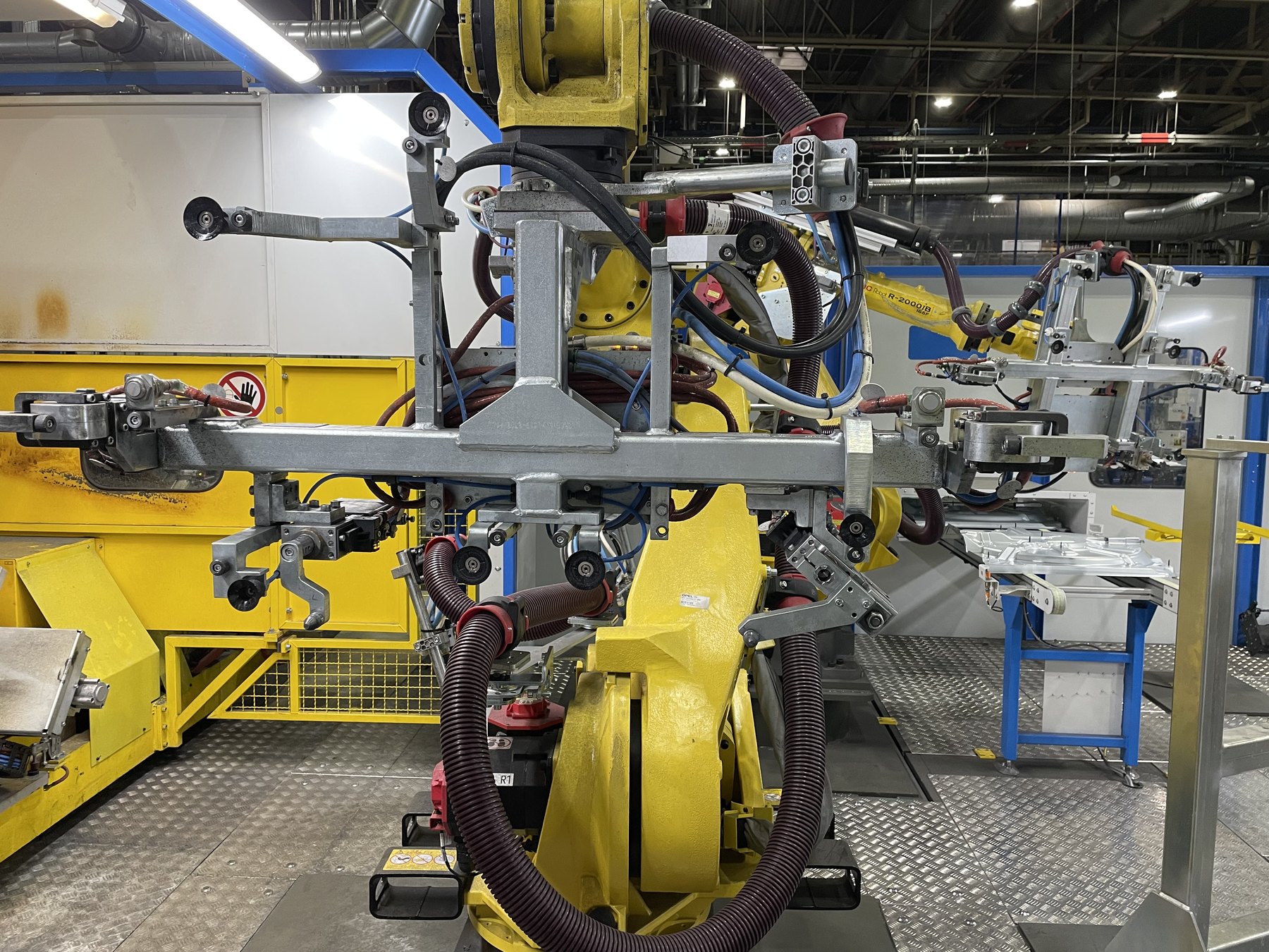 Spot and projection welding cell — FANUC robots, welding guns and part fixtures.